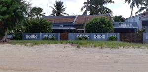 a house behind a fence on the beach at Férias na Praia do Tofo, relaxantes e únicas in Praia do Tofo