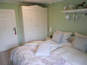 a bedroom with a large bed with white sheets at Dollhouse Modern retreat in Wiesmoor
