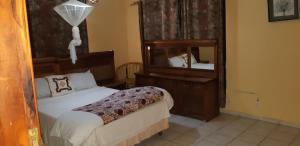 ein Schlafzimmer mit einem Bett und einem großen Spiegel in der Unterkunft Férias na Praia do Tofo, relaxantes e únicas in Praia do Tofo