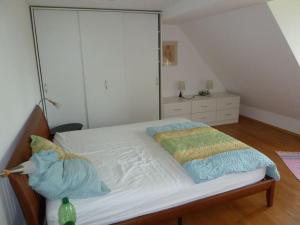 a bedroom with a white bed with a large closet at Fisherman's house on Lake Malkwitz 