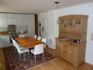 a kitchen with a wooden table and white chairs at Fisherman's house on Lake Malkwitz 
