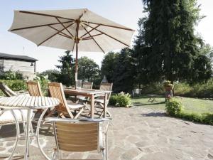 a table and chairs with an umbrella on a patio at Fisherman's house on Lake Malkwitz 