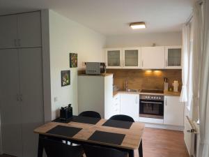 a kitchen with a table and chairs and a kitchen with white cabinets at Pure nature, modern retreat in Lenz