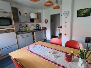 een keuken met een houten tafel en rode stoelen bij A Heyne Modern retreat in Weinböhla