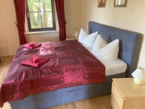 a bedroom with a bed with red sheets and pillows at Holiday home bastion in Lohmen