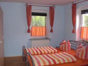 a bedroom with a bed and a window with orange curtains at "Heidi" Modern retreat in Kirschau