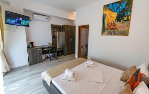 a bedroom with a bed and a tv in a room at Casa Amelie Mangalia in Mangalia