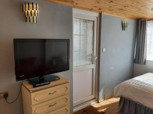 - une chambre avec une télévision à écran plat sur une commode dans l'établissement Mildenhall Suffolk, à Mildenhall