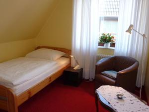 Maiken Feikes, "Am Friedrichshain" في فينينغستيدت: غرفة نوم بها سرير وكرسي ونافذة