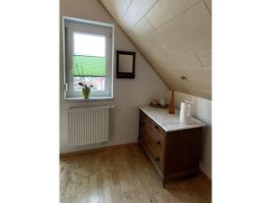 a attic room with a sink and a window at Holiday apartment Kromer in Jechtingen