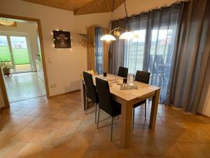 a dining room with a wooden table and chairs at Holiday apartment Kromer in Jechtingen +27 photos