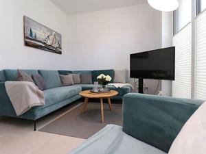un soggiorno con divano blu e tavolo di Villa Ostseekind a Neuhaus
