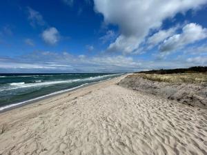 a sandy beach with the ocean on a cloudy day at Villa Ostseekind in Neuhaus