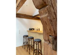 uma cozinha com bancos de bar e uma parede de pedra em Zum Bräu Modern retreat em Polling