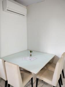 una mesa de comedor blanca con sillas blancas en Ikigai Brasil Houses, en Foz do Iguaçu