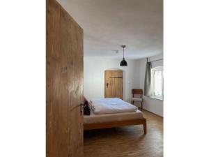 um quarto com uma cama e uma porta de madeira em Zum Bräu Modern retreat em Polling