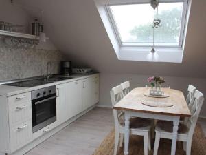a kitchen with a table with chairs and a window at Dorpsbeauty aan de Oostzee in Rellin +26 photos