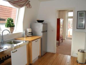 a kitchen with a sink and a refrigerator at Wonen & Wellness - in Travemünde in Travemünde