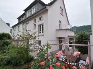 a white house with chairs and flowers in front of it at Haus Rosa Comfortable holiday residence in Cochem
