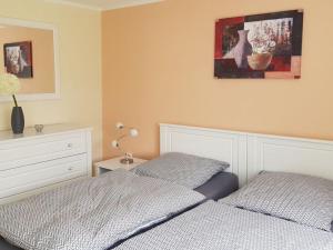 a bedroom with two beds and a painting on the wall at Lighthouse view Modern retreat in Bastorf