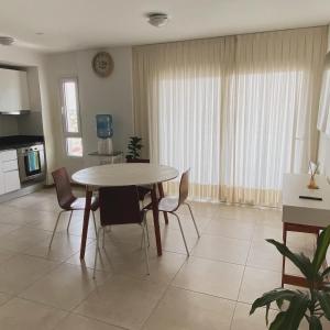 a kitchen and dining room with a table and chairs at Departamento Séptimo Portal Norte in Concordia