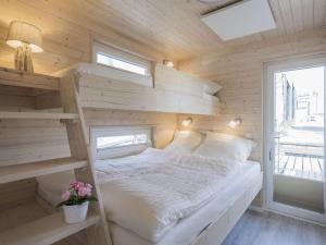 a bedroom with a bed in a wooden wall at Baltic Sea Swantje Modern retreat in Heiligenhafen