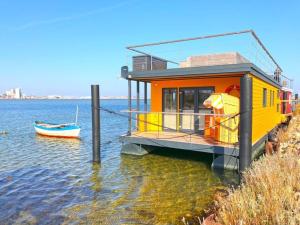 a house on the water next to a boat at Baltic Sea Swantje Modern retreat in Heiligenhafen