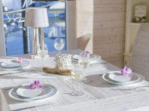 a table with white plates and glasses and purple flowers at Baltic Sea Swantje Modern retreat in Heiligenhafen