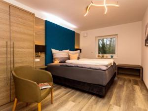Schlafzimmer mit einem Kingsize-Bett und einem Stuhl in der Unterkunft Dreamtime Modern Retreat in Zinnowitz