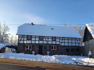 a house covered in snow with snow on top of it at Eifel Oasis Comfortable holiday residence in Monschau