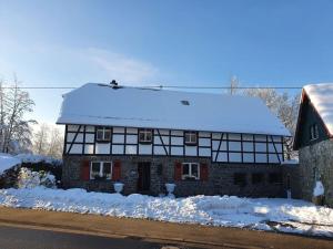 a house covered in snow with snow on top of it at Eifel Oasis Modern retreat in Monschau