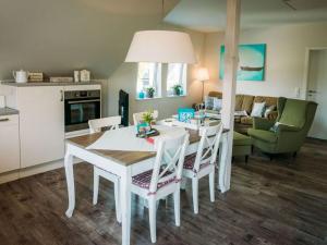 a kitchen and living room with a white table and chairs at Hoppetosse Comfortable holiday residence in Schönberger Strand +34 photos
