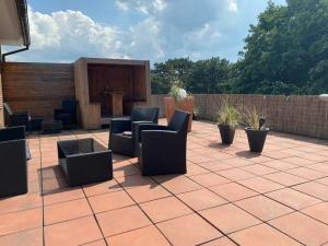 a patio with couches and chairs on a brick patio at Charly"s Sweet Modern retreat in Norderney