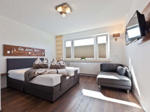 a bedroom with a bed and a couch and a television at Charly"s Sweet Modern retreat in Norderney