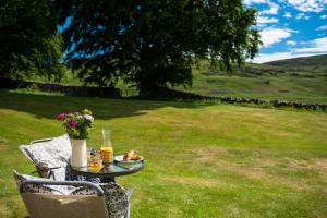 una mesa con un plato de comida en el césped en Colmeallie Bothy - Seasgair Lodges en Brechin