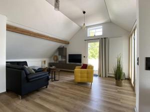 uma sala de estar com um sofá e uma cadeira amarela em Haus Mariechen Modern retreat em Frielendorf