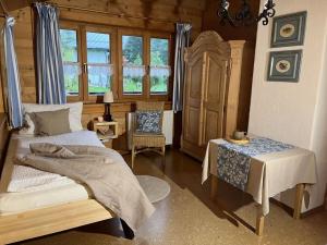 a bedroom with a bed and a table and a chair at Malerhäusl Modern retreat in Schönau am Königssee