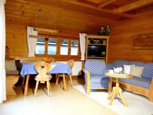 sala de estar con sofá, mesa y sillas en Malerhäusl Modern retreat, en Schönau am Königssee