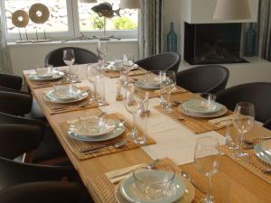 a long wooden table with plates and glasses on it at Villa Bi de Kühlung Comfortable Vacation Home in Neu Gaarz