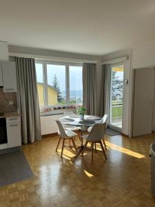 Minusio Swiss Vacances في Minusio: مطبخ وغرفة طعام مع طاولة وكراسي