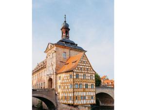 un edificio con una torre de reloj junto a un puente en Concordia33 Modern retreat en Bamberg