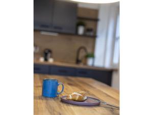 a blue coffee mug and a piece of bread on a table at Concordia33 Modern retreat in Bamberg