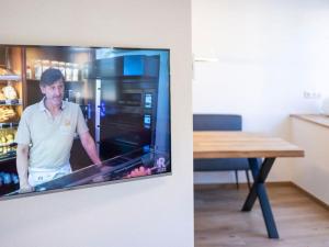 a tv on a wall with a man in a refrigerator at Concordia33 Modern retreat in Bamberg