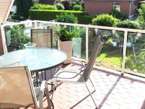 a patio with a glass table and two chairs at in the house Am Redder in Flintbek