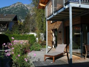 une chaise assise sur une terrasse à côté d'un bâtiment dans l'établissement Moonwood Modern Retreat, à Garmisch-Partenkirchen