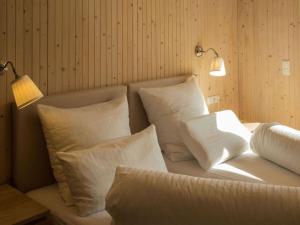 - un lit blanc avec des oreillers blancs et une lampe dans l'établissement Moonwood Modern Retreat, à Garmisch-Partenkirchen
