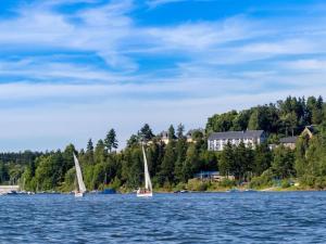 dos veleros en un lago con un pueblo en el fondo en Saaleland Apartment 2, en Schleiz