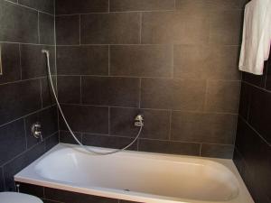 La salle de bains est pourvue d'une baignoire avec un tuyau. dans l'établissement Moonwood Modern Retreat, à Garmisch-Partenkirchen