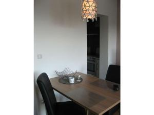 une salle à manger avec une table en bois et des chaises noires dans l'établissement Saaleland Apartment 1, à Schleiz