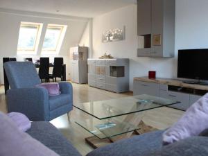 a living room with two chairs and a glass table at Farsighted modern retreat in Annaberg-Buchholz